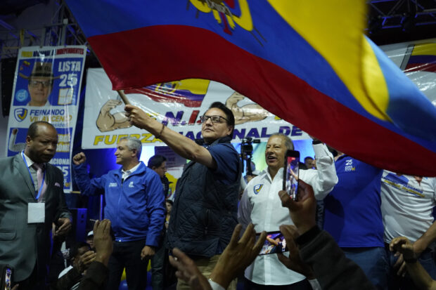 Presidential candidate Fernando Villavicencio waves an Ecuadorean flag during a campaign event at a school minutes before he was shot to death outside the same school in Quito, Ecuador, Wednesday, Aug. 9, 2023 (API via AP)