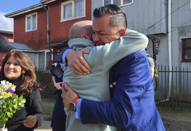 In this image provided by Constanza Del Rio/Nos Buscamos, Jimmy Thyden, right, hugs his brother Pablo Leiva Gonzalez as Maria Angelica Gonzalez, his Chilean birth mother, left, looks on in Valdivia, Chile on Aug. 17, 2023. 