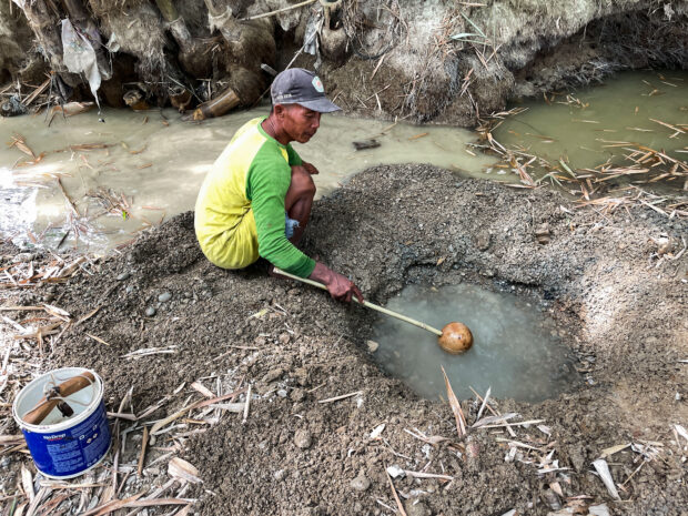 Indonesian villagers dig up dry river bed in drought