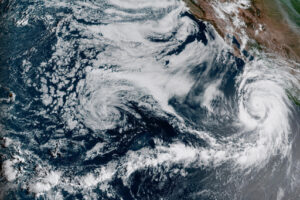EDT satellite image provided by the National Oceanic and Atmospheric Administration shows Hurricane Hilary, right, off Mexico’s Pacific coast. 