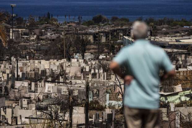 A man views the aftermath of a wildfire in Lahaina, Hawaii, Saturday, Aug. 19, 2023