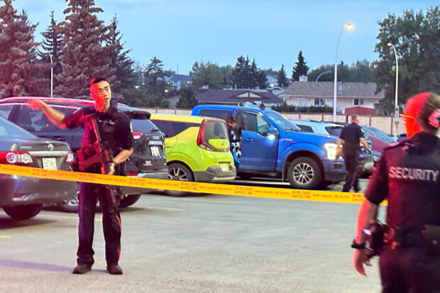 A police officer speaks with security personnel after a shooting incident at the West Edmonton Mall