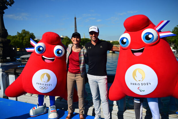 Olympic Phryges mascots pose for a photograph with French Sports Minister Amelie Oudea-Castera (Centre-L) and President of the Paris 2024 Olympics, Tony Estanguet (Centre-R) on the Alexandre III bridge with the Eiffel Tower in the background after the mixed relay and last day of the 2023 World Triathlon- duathlon format of the Olympic Games Test Event in Paris, on August 20, 2023. (AFP)