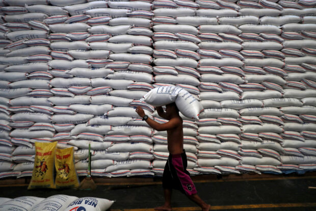A worker carries on his head a sack of rice inside a government rice warehouse National Food Authority in Quezon city, Metro Manila in Philippines, Aug. 9, 2018.