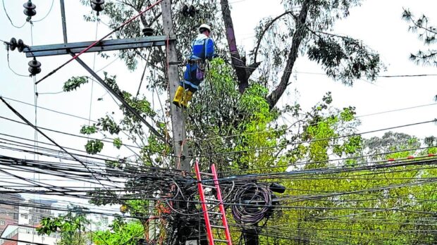 POWER FIXER A utility man works on an electric post in Baguio City in Benguet province. —ALLAN MACATUNO