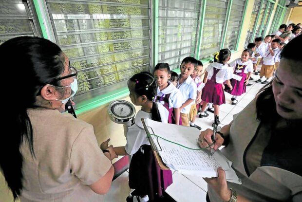 NUTRITION CHECK Teachers record the height and body mass index of pupils at Aurora A. Quezon Elementary School in San Andres, Manila, as the Department of Education prepares the baseline nutritional status assessment of students for the school-based feeding program. —RICHARD A. REYES