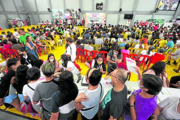 Small rice retailers queue for a P15,000 cash aid from the government meant to make up for expected losses due to the price cap ordered by President Marcos on Sept. 5, 2023.
