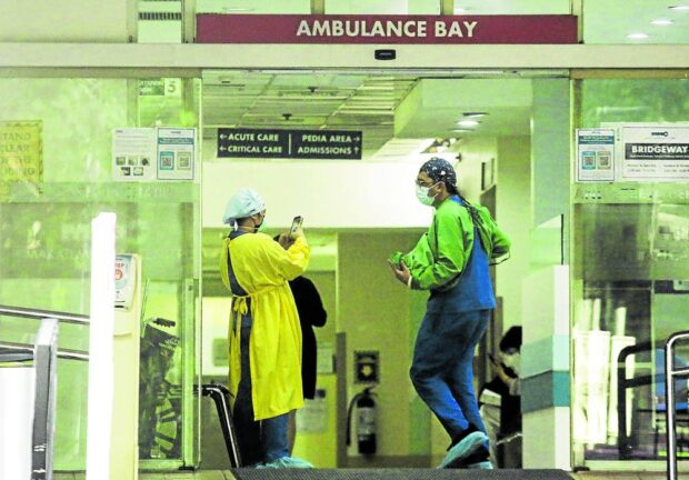 Emergency room personnel share a light moment at the ambulance bay of the Makati Medical Center.