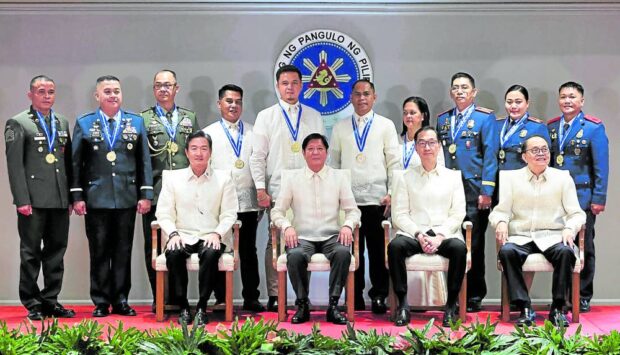 RECOGNITION President Marcos with this year’s batch of Metrobank Foundation’s OutstandingFilipino awardees (back row) Col. Joseph Dator, Lt. Col. Joseph Bitancur, Staff Sgt. Danilo Banquiao, Police Chief Master Sgt. Dennis Bendo, Police Maj. Mae Ann Cunanan, June Elias Patalinghug, Rex Sario, Jovelyn Delosa, Edgar Durana and Police Col. Renell Sabaldica. Seated are Metrobank director Alfred Ty, Metrobank chair Arthur Ty and Metrobank Foundation president Aniceto Sobrepeña. —MARIANNE BERMUDEZ