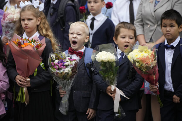 First graders take part in a ceremony marking the start of classes at a school as part of the traditional opening of the school year known as "Day of Knowledge" in St. Petersburg, Russia, Friday, Sept. 1, 2023. 