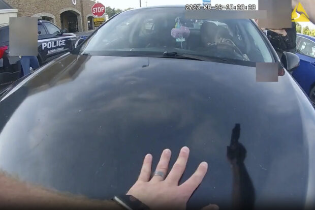 This still image from bodycam video released by the Blendon Township Police on Friday, Sept. 1, 2023, shows an officer pointing his gun at Ta’Kiya Young moments before shooting her through the windshield outside a grocery store in Blendon Township, Ohio, a suburb of Columbus, on Aug. 24. The pregnant Black mother was pronounced dead shortly after the shooting. Her unborn daughter did not survive. The video was pixelated by the source. (Blendon Township Police via AP)