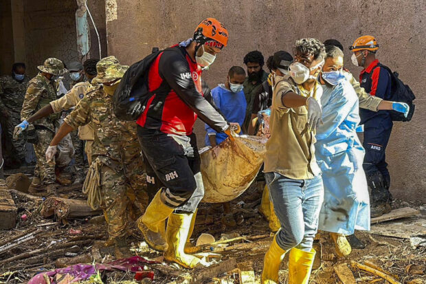 In this photo provided by Turkey’s IHH humanitarian aid group, rescuers retrieve the body of a flooding victim in Derna, Libya, Wednesday, Sept.13, 2023. Search teams are combing streets, wrecked buildings, and even the sea to look for bodies in Derna, where the collapse of two dams unleashed a massive flash flood that killed thousands of people. 