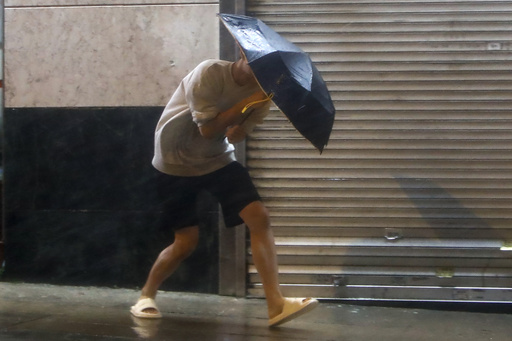 A man with an umbrella struggles against strong wind and rain 