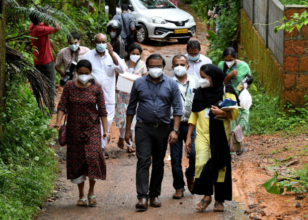 Members of a medical team from Kozhikode Medical College carry areca nut and guava fruit samples to conduct tests for Nipah virus in Maruthonkara village