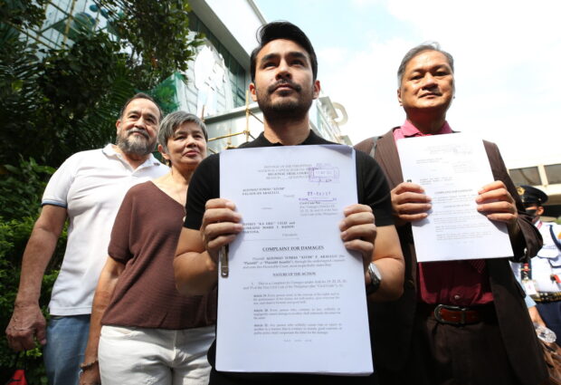 PUSHBACK Broadcast journalist Atom Araullo on Monday shows reporters a copy of his complaint for civil damages against Lorraine Marie Badoy-Partosa and Jeffrey Celiz for Red-tagging him and his family. Badoy, a former spokesperson for the government’s anticommunist task force, and Celiz are hosts of “Laban Kasama ang Bayan” on SMNI. With Araullo are his legal counsel Antonio “Tony” La Viña (right) and his parents Miguel and Carol, Bayan chair emeritus. —LYN RILLON  sue smni red-tagging