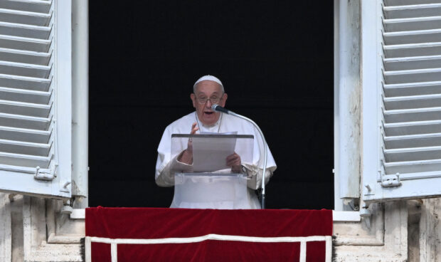 Pope Francis addresses the crowd from the window of the apostolic palace overlooking St. Peter's square during the weekly Angelus prayer on October 22, 2023 in The Vatican. (Photo by Andreas SOLARO / AFP)