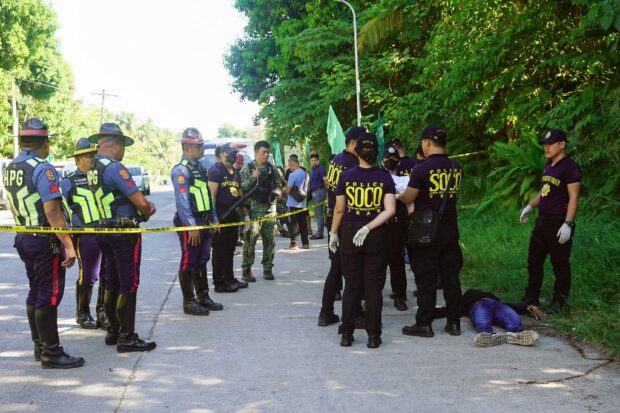 Police gather evidence beside bodies at the scene of a shooting outside a polling station following a confrontation between supporters of rival candidates, during the nationwide village and youth representative elections in Datu Odin Sinsuat town on Mindanao island on October 30, 2023. Security forces were on high alert across the Philippines on October 30 as millions of people voted for village leaders following months of deadly poll-related violence. (Photo by Ferdinandh CABRERA / AFP)