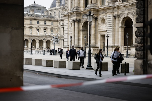 Staff leave the Louvre Museum as people are evacuated after it received a written threat