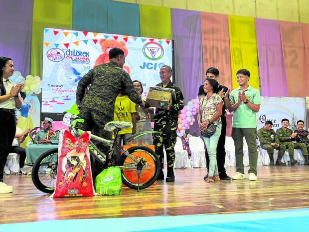 Civilian militia member Wilbert Garcia shakes hands with Brig. Gen. Alvin Luzon, commander of the Army’s 101st Infantry Brigade based in Basilan, after being honored as among the local heroes in the fight against the Abu Sayyaf in Basilan province.