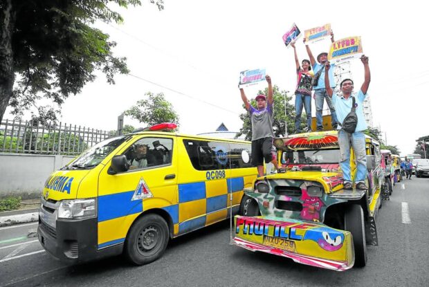 HEAR US  Public utility vehicle drivers use a jeepney as a platform to air their grievances against the government’s transportation agencies and officials during the strike led by the group Manibela on Monday. Their protest caravan stopped on East Avenue in Quezon City before proceeding to Manila. —LYN RILLON