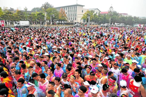 RUNNING IN TIANANMEN SQUARE Some 30,000 people join the Beijing Marathon on Sunday. —REUTERS     
