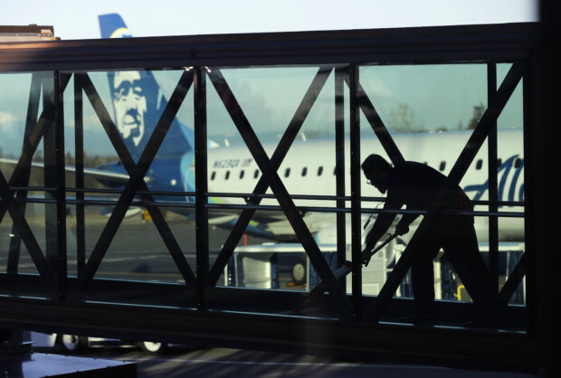 A worker cleans a jet bridge at Paine Field in Everett, Washington