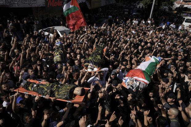 Palestinians Carry bodies of militants killed in clashes during an Israeli rad in Jen refugee camp in the West Bank on Monday, Oct. 30, 2023.