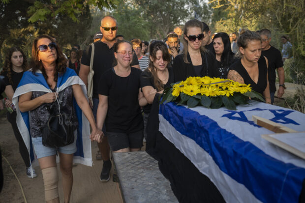 Relatives attend the funeral of Albert Miles, 81, at the Kibbutz Revivim cemetery, south Israel, Monday, Oct. 30, 2023. 