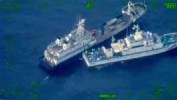 This image released by the Armed Forces of the Philippines, shows a Chinese militia vessel, top, and Philippine coast guard vessel BRP Cabra as they approach Second Thomas Shoal, locally called Ayungin Shoal, at the disputed South China Sea on Sunday October 22, 2023. (Armed Forces of the Philippines via AP)