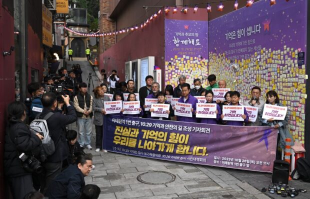 Families of Itaewon crush victims hold signs reading "I will remember the 10.29 Itaewon disaster!"