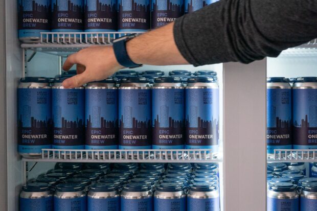 Aaron Tartakovsky, cofounder and CEO of water technology startup Epic Cleantec, reaches into a refrigerator of beers brewed with recycled wastewater at the company headquarters in San Francisco, California, on Sept. 26, 2023.