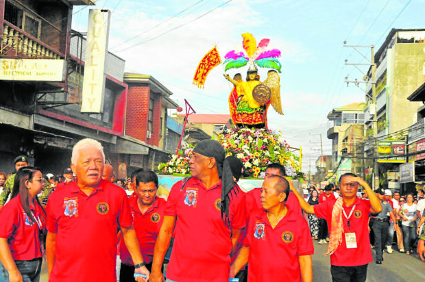 Members of the “panaad,” a group whose members vowed to protect the image of St. Michael, lead the procession around Iligan City so people will catch a glimpse of their patron. 