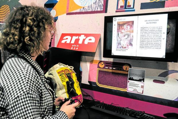 THINK PIECE A visitor plays a video game on the stand of the Franco-German public service channel Arte during the “Paris Games Week” fair on Nov. 1. —AFP