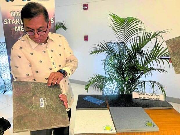 ECOFRIENDLY Science Secretary Renato Solidum Jr. shows the ecofriendly “plastic tiles” developed by the Department of Science and Technology using radiation technology. —JANE BAUTISTA
