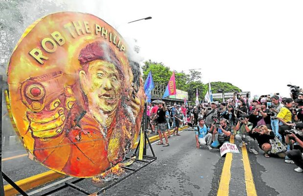 FIERY RALLY Protesters prepare to burn the effigy of President Marcos on Commonwealth Avenue ahead of his State of the Nation Address last July. —LYN RILLON