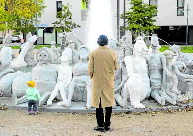 WHAT A SIGHT A man and a child look at the sculpture “WirWasser Brunnen” (Our Water Fountain) created by artist group Gelitin in Vienna, Austria, on Nov. 8. The sculpture, surrounding a fountain, was inaugurated last month to mark the 150th anniversary of drinking water coming from the Alps. —AFP