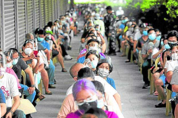 VAX PRIORITY People belonging to the A1-A3 priority group line up for vaccination at a hotel in Manila in this file photo. —INQUIRER FILE PHOTO
