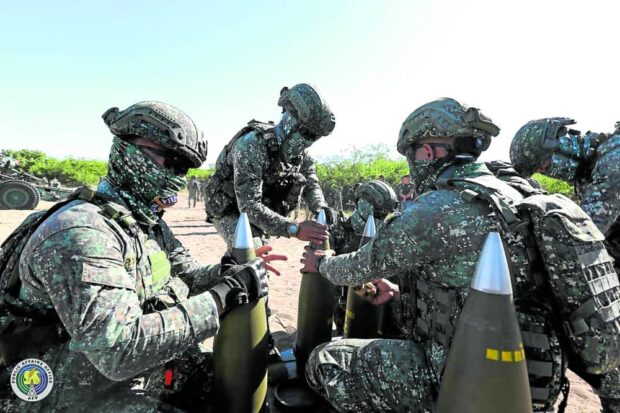 DEFENSIVE READINESS Members of the Philippine Marines (left photo) prepare artillery rounds during Wednesday’s Ajex-Dagitpaexercises with other branches of the military on the coast of Burgos town in Ilocos Norte. —PHOTO FROM THE ARMED FORCES OF THE PHILIPPINES
