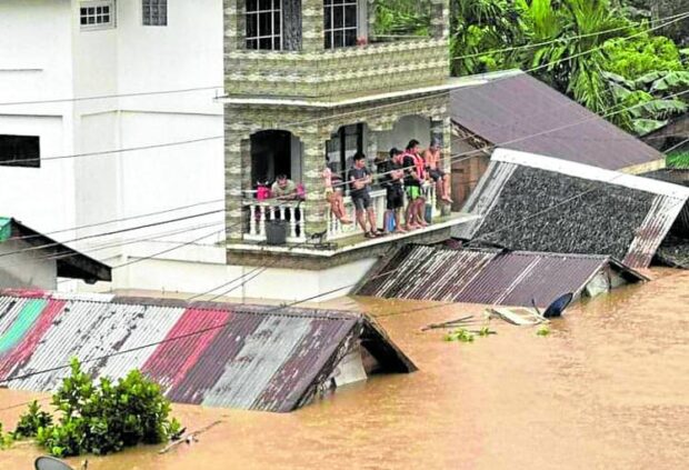 WAITING FOR RESCUE Residents of Lope de Vega in Northern Samar wait for rescuers on Tuesday amid a flood that inundated houses due to incessant rains spawned by a low pressure area and shear line since Sunday. —PETER PAREDES/contributor