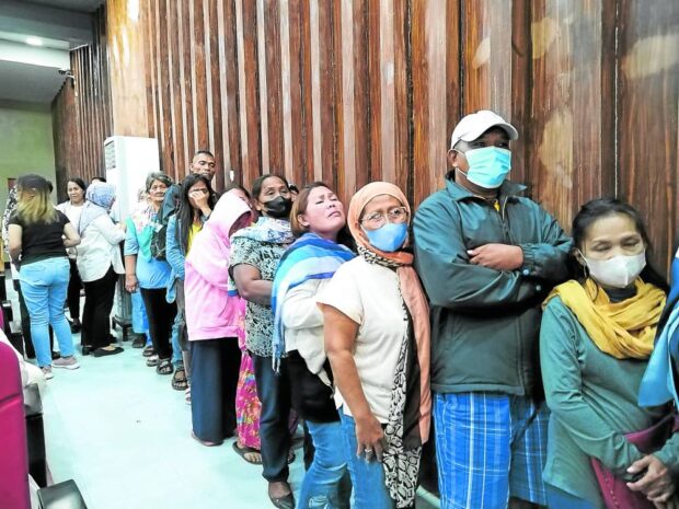 The first batch of 22 families of those killed in the 2017 Marawi siege line up to receive their compensation checks on Monday, Nov. 20, 2023. in Marawi City.