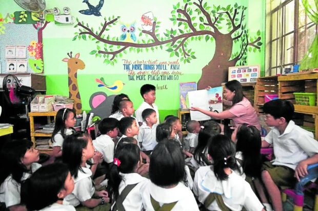 PAGE-TURNER Story time at Ibalon Central School in Legazpi City, Albay province, where pupils gather at their “Reading Corner” in this photo taken on March 2, 2020. —Mark Alvic Esplana