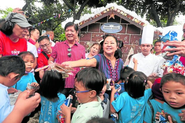 GIFT-GIVING President Marcos and first lady Liza Araneta- Marcos hand out gifts and food treats to children from selected shelters and orphanages during the nationwide gift-giving day at Malacañang Palace on Sunday. —MARIANNE BERMUDEZ