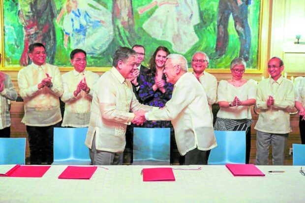 FRESH START Presidential peace adviser Carlito Galvez Jr. says the agreement between the government and the National Democratic Front of the Philippines (NDFP) is “not a resumption of [peace] talks, nor a restart” but a new beginning. A Nov. 23 handout photo shows President Marcos’ special assistant Antonio Lagdameo Jr. shaking hands with NDFP chair Luis Jalandoni. —AFP