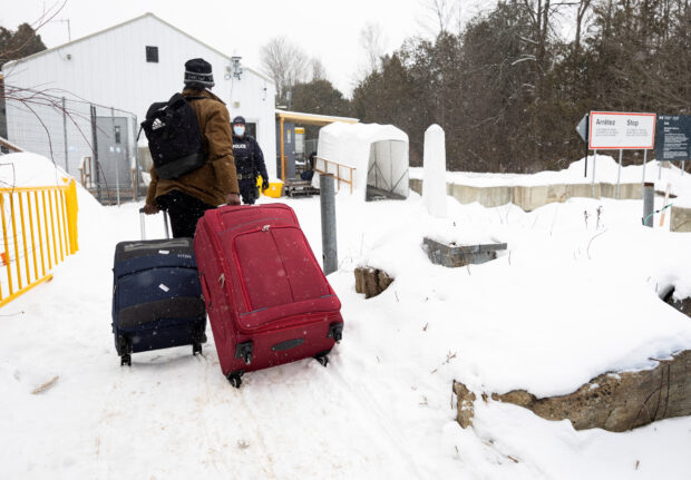 Asylum seekers cross into Canada from Roxham Road in Champlain, New York