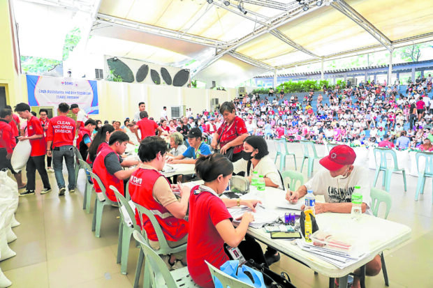 DSWD workers in Valenzuela City process applications for rice and cash aid