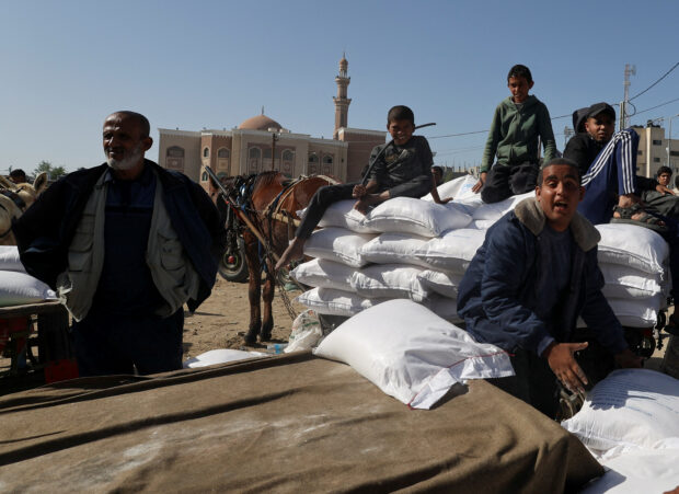 Palestinians gather to receive flour distributed by UNRWA