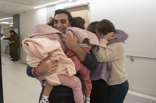 Aviv Asher, 2,5-year-old, her sister Raz Asher, 4,5-year-old, and mother Doron, react as they meet with Yoni, Doron's husband and their father, after they returned to Israel to the designated complex at the Schneider Children's Medical Center on Friday, Nov. 24, 2023. A four-day cease-fire in the Israel-Hamas war began in Gaza on Friday with an exchange of hostages and prisoners. (Schneider Children’s Medical Center via AP)