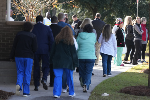 Staff members at Phoebe Sumter Medical Center arrive to watch the departure of the casket of former first lady Rosalynn Carter at Phoebe Sumter Medical Center in Americus, Ga., Monday, Nov. 27, 2023. The former first lady died on Nov. 19. She was 96. (AP Photo/Alex Brandon, Pool)
