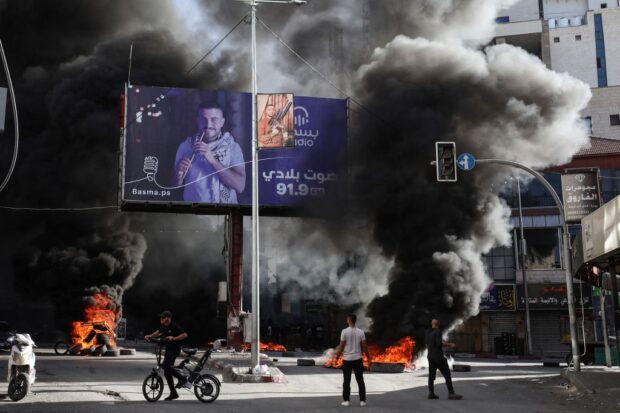 Palestinian youths burn tyres during confrontations with Israeli forces in the occupied West Bank city of Jenin on November 9, 2023.