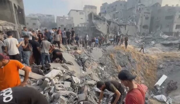 This image grab taken from AFPTV video footage shows Palestinians looking for survivors in a crater following a stike on a refugee camp in Jabalia on the northern Gaza Strip, on October 31, 2023.